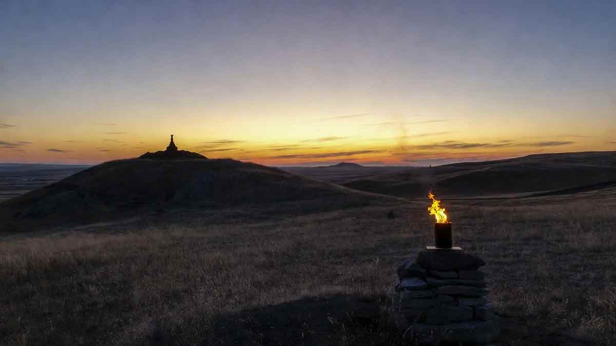 Захід сонця над Луганським степом, запалена свіча пам'яті, силует кургану