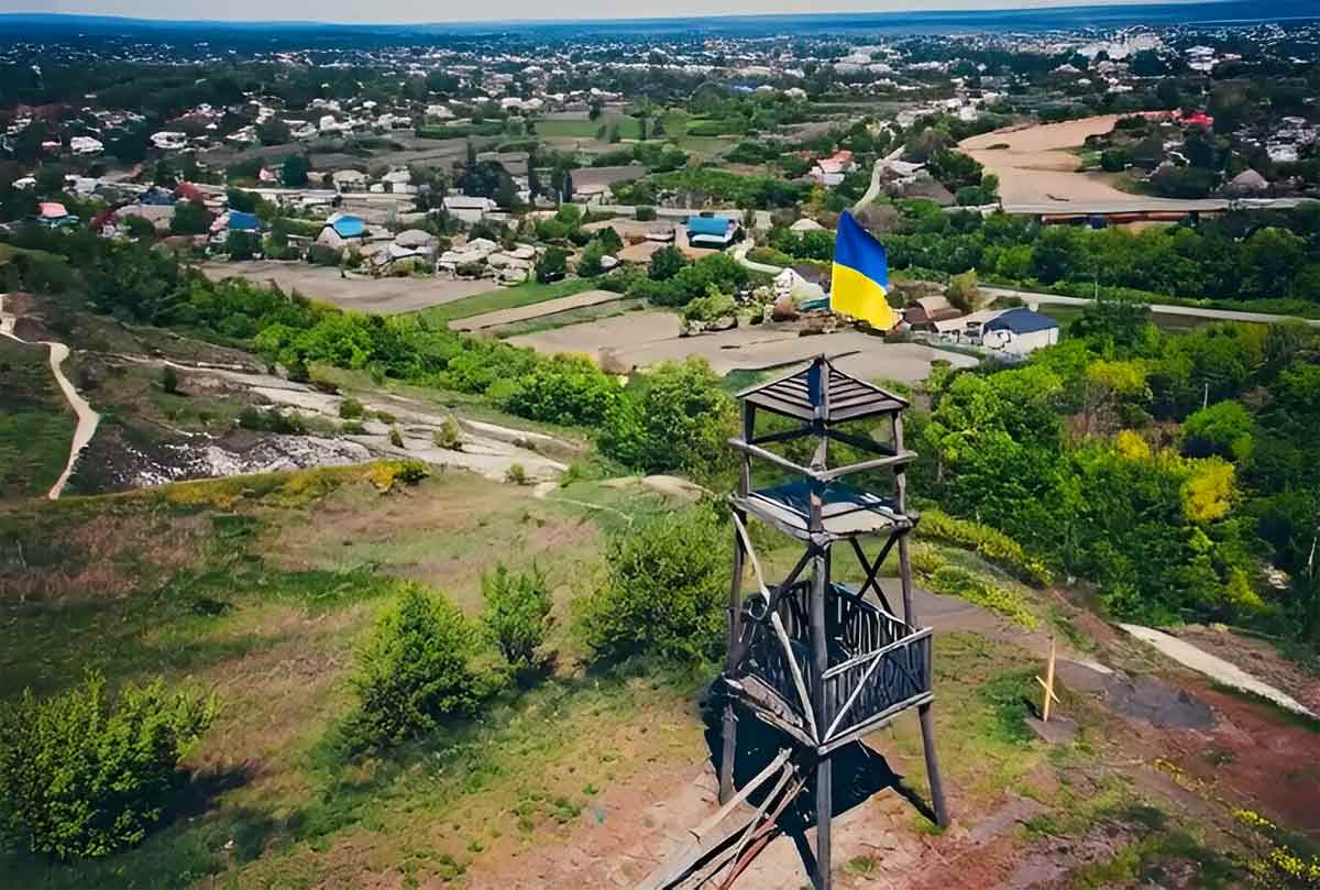 Дерев'яна козацька вежа на горі у Сватовому, світанок, соняшникові поля в тумані