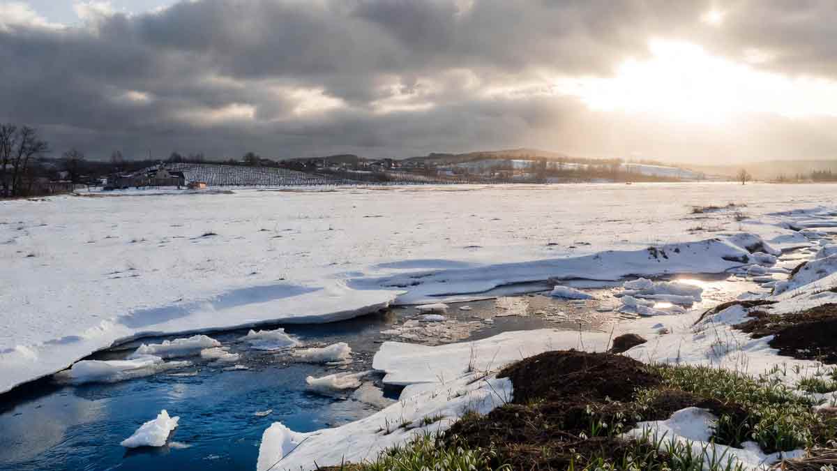 Реалістичний пейзаж Сватівщини, річка скресає від льоду під променями сонця, перші проліски на снігу