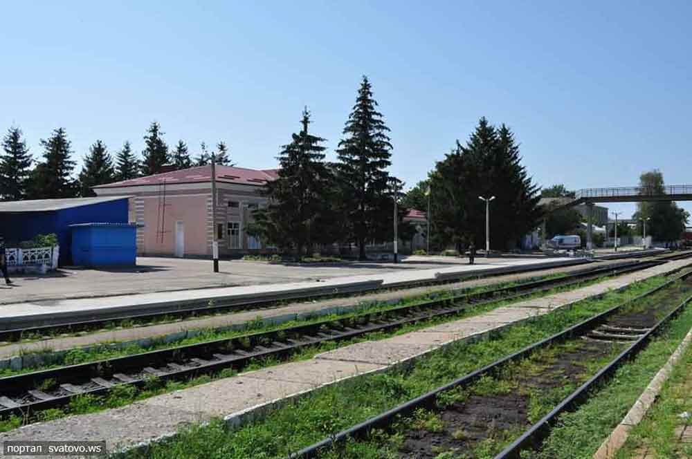 Стара будівля станції Сватове, рейки йдуть у далечінь, світанок, зелене світло семафора